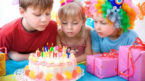 Дети задувают свечи на торте